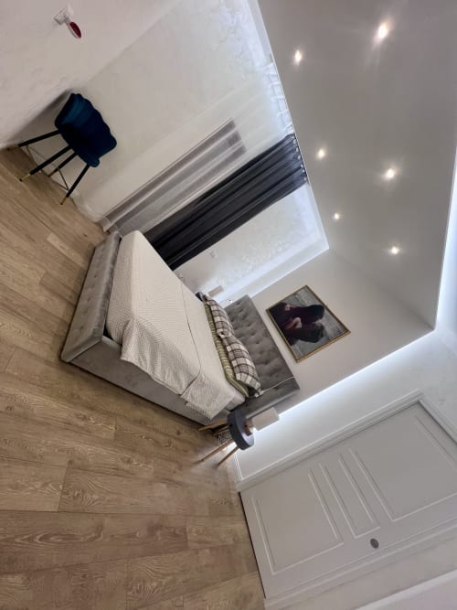 Camera da letto moderna nell'appartamento Zoelia Roma con letto, scrivania, pavimenti in legno e luci incassate al soffitto