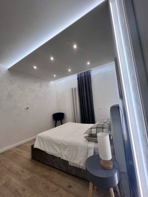 Camera da letto moderna dell'appartamento Zoelia Rome con specchio illuminato, letto, scrivania e illuminazione contemporanea