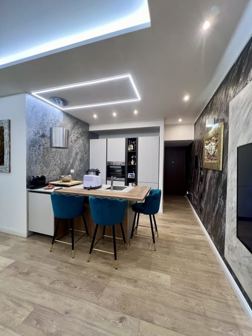 Zona living-cucina moderna dell'appartamento Zoelia Roma con sedie blu, tavolo in legno e illuminazione di design