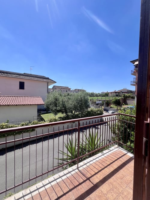 Vista dal balcone dell'appartamento Zoelia a Roma: terrazza in cotto, ringhiera metallica, ulivi e circondario