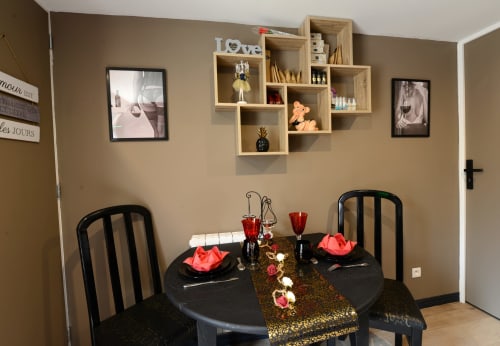 Ambiance romantique dans la Love Room des Secrets de Winna, table noire élégante avec accents rouges et décoration