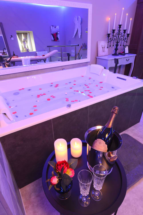 Suite de bain luxueuse et romantique avec champagne, roses, bougies et pétales de rose aux Secrets de Winna, Deux-Sèvres