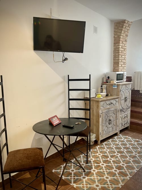Room 3 at Complejo Turístico Retiro del Teatro features flat-screen TV, round table, wooden furniture and patterned rug.