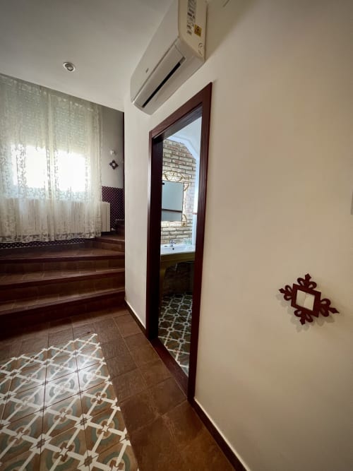Hallway in Room 3 at Complejo Turístico Retiro del Teatro, Almagro, with terracotta tiles and dark wooden door to balcony