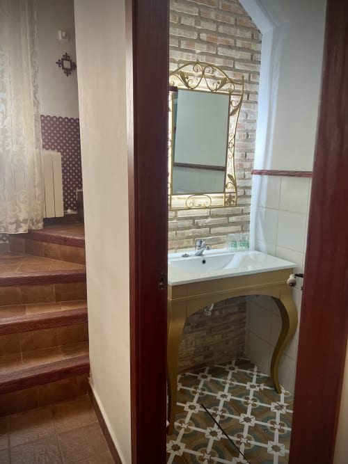 Bathroom in Room 3 at Complejo Turístico Retiro del Teatro with sink, ornate mirror, and decorative floor tiles
