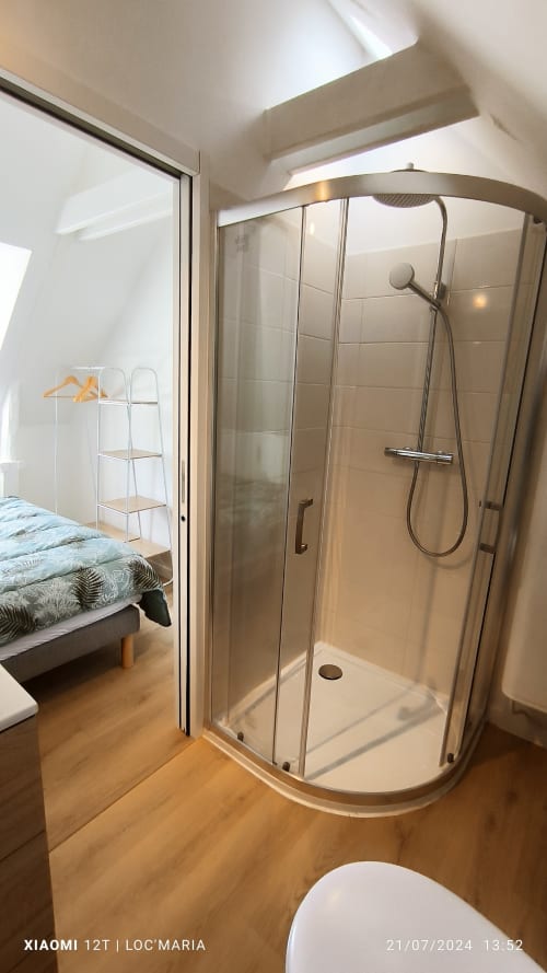 Élégante douche avec paroi courbe en verre et douchette pluie dans un appartement de vacances à Belle île en Mer