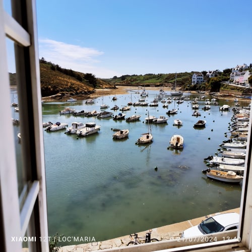 Vue panoramique du port de Locmaria, Belle-Île-en-Mer avec bateaux amarrés et bâtiments du village côtier