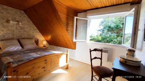 Chambre lumineuse à Loc'Maria, Belle Île, avec poutres apparentes, vue sur le jardin et mobilier rustique