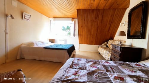 Chambre de cottage avec deux lits, plafond en bois, TV et vue sur le jardin à Loc'Maria, Belle Île en Mer