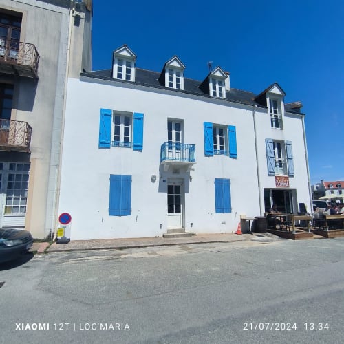 Appartement aux murs blancs avec volets bleus et lucarnes à Locmaria, Belle Île, France