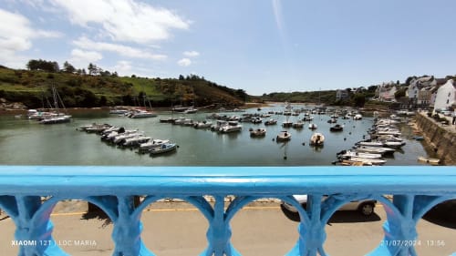 Balustrade bleue colorée surplombant les bateaux amarrés à Locmaria, Belle-Île-en-Mer, Bretagne