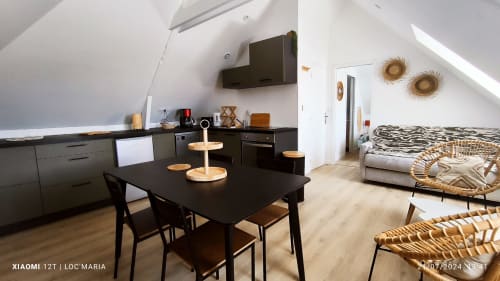 Appartement moderne ouvert à Locmaria, Belle Île avec cuisine noire, table à manger et coin salon beige