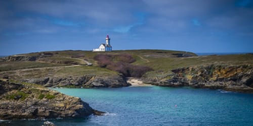 Phare sur les falaises côtières de Belle-Île-en-Mer, eaux turquoise et crique rocheuse