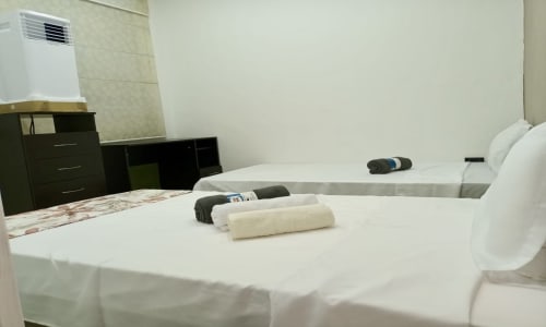 Habitación limpia del hotel Casa Mango en Cali con camas blancas, toallas enrolladas y mobiliario moderno