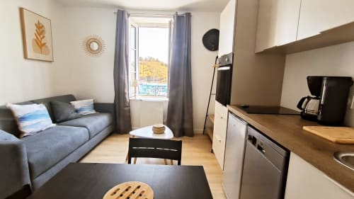 Studio Le Prince de Guerveur à Belle Île avec vue mer, canapé gris, kitchenette, coin repas et décor moderne
