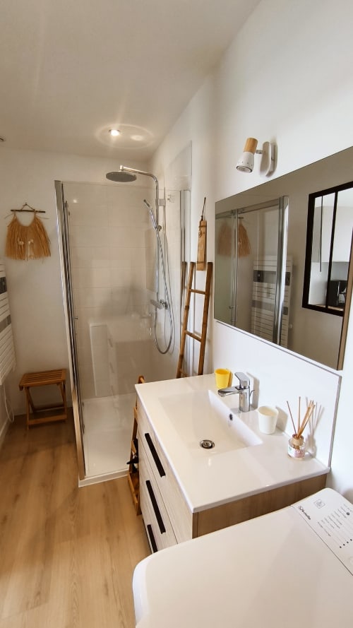 Salle de bains moderne du Studio Le Prince de Guerveur, Belle Île en Mer, avec lavabo blanc, miroir, douche et boiseries