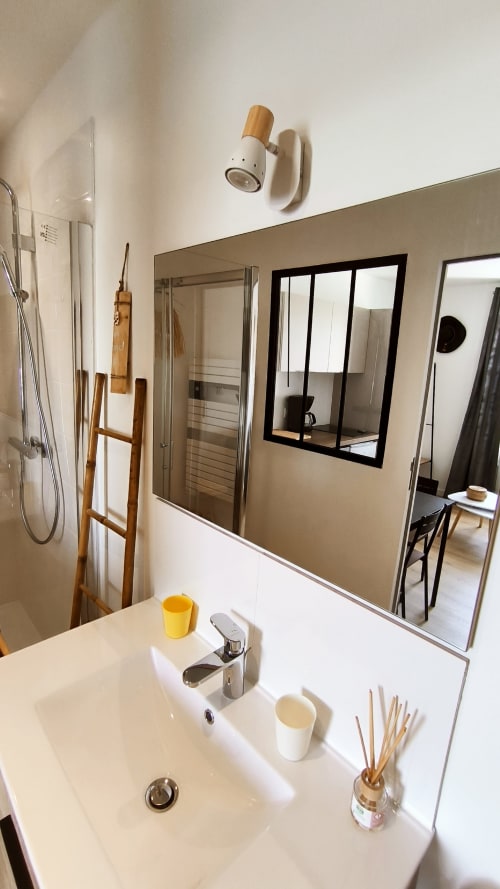 Salle de bains moderne du Studio Le Prince de Guerveur, Belle Île en Mer, avec lavabo blanc, miroir et touches de bois