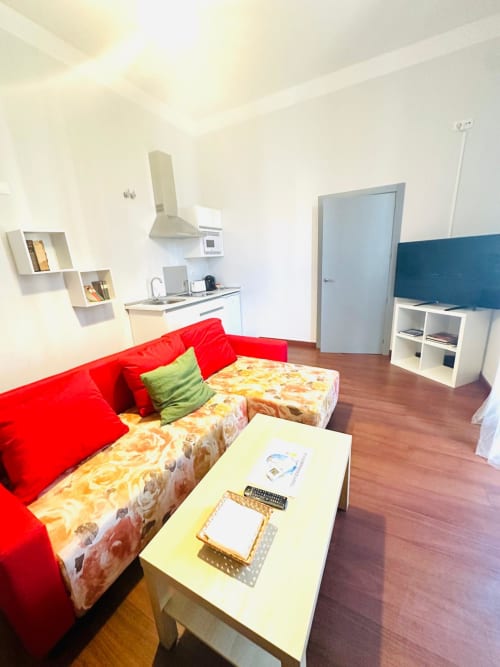 Apartamento moderno en Mérida con sofá rojo, cocina integrada y sala de estar abierta