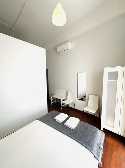 Dormitorio moderno del apartamento Gestyp-AT en Mérida con cama, espejo, aire acondicionado e iluminación colgante