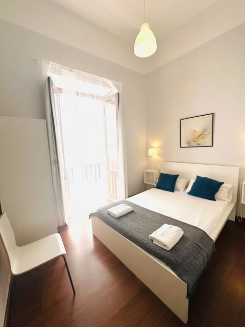 Habitación luminosa en apartamento Gestyp-AT en Mérida con cama queen, suelos de madera oscura y vista al balcón
