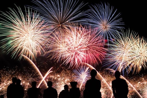 Silhouettes d'invités au Château De Brie regardant un spectaculaire feu d'artifice dans le ciel nocturne