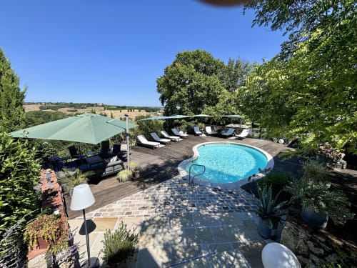 Maison Mûrier pool terrace in Fayssac with blue water, loungers, umbrellas and rural views