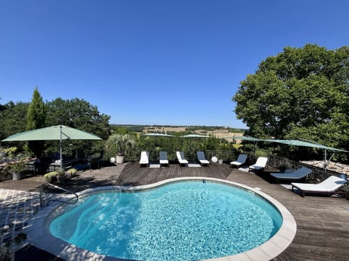 Maison Mûrier poolside terrace with loungers, umbrellas, and Fayssac countryside views