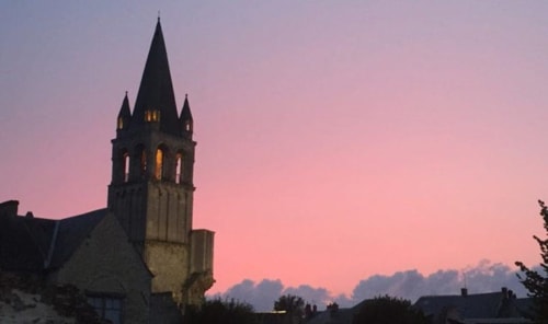 Tour d'église médiévale illuminée au crépuscule à Châteauroux, France, près du gîte Le Fassardy