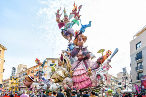 Colorido desfile de carrozas de carnaval en Burriana, España con figuras elaboradamente decoradas y festividades tradicionales