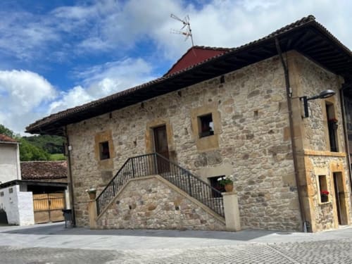 Edificio de piedra Las Llaviadas en Ortiguero de Cabrales con vistas montañosas y arquitectura tradicional