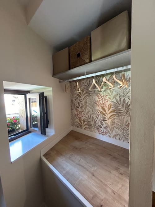 Acogedor rincón en Las Llaviadas con papel de pared botánico, estantería de madera y vista a las montañas desde la ventana en Cabrales