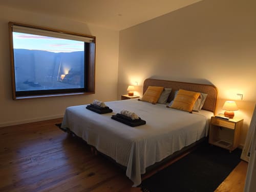 Quarto elegante na Quinta do Fraguil com janela com vista para o rio Douro, cama de madeira com almofadas laranja e