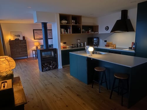 Cozinha de quinta moderna com armários azuis, bancada central e área de estar integrada na Quinta do Fraguil, Douro