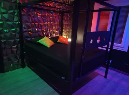 Chambre moderne de la villa La Maison du Plaisir avec éclairage néon, panneaux muraux géométriques et décoration LED colorée