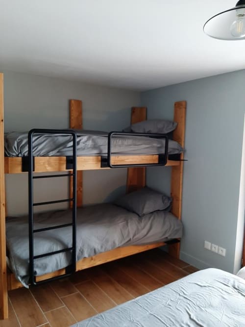 Chambre spacieuse de l'appartement 204B dans la résidence l'Albane à Vars-les-Claux, équipée d'un lit double et de deux lits superposés, idéale pour accueillir familles et groupes dans un espace confortable et convivial.