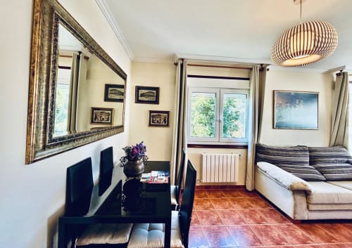 Dormitorio espacioso con cama doble, escritorio, espejo y luz natural en la casa rural Casa Caeiro de Baiona
