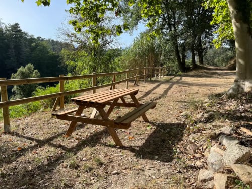 Table de pique-nique en bois et balustrade offrant une vue sur la nature au gîte rural Can Ricós à Vallgorguina, Barcelone