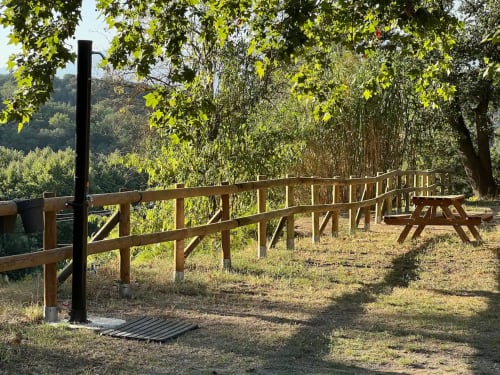 Area picnic rustica con panche ombreggiate dagli alberi presso l'ostello rurale Can Ricós a Vallgorguina, Barcellona