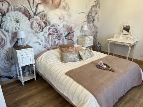 Elegant bedroom at Château Ségot B&B in Neuilly-le-Réal with floral wallpaper, cream bedding, and antique white furniture