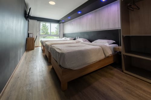 Moderna habitació familiar per a 5 persones a l'Hôtel Rocade de Pamiers amb llits bessons, vistes al jardí i comoditats contemporànies