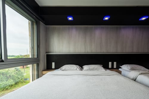 Habitació familiar moderna per a 5 persones a l'Hôtel Rocade a Pamiers amb llits bessons, vistes al jardí i disseny contemporani negre i fusta