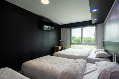 Moderna habitació familiar per a 5 persones a l'Hôtel Rocade a Pamiers amb llits bessons, televisió de pantalla plana i vistes al jardí