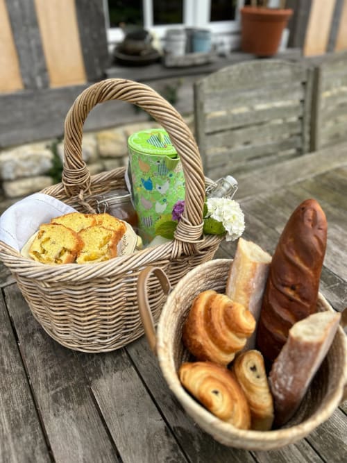 Outdoor picnic basket with fresh pastries and bread at Domaine de Blanvatel B&B in Saint Pierre en Auge