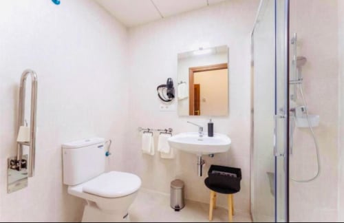 Baño moderno en apartamento Gestyp-AT, Mérida con inodoro, lavamanos, espejo, ducha y paredes blancas