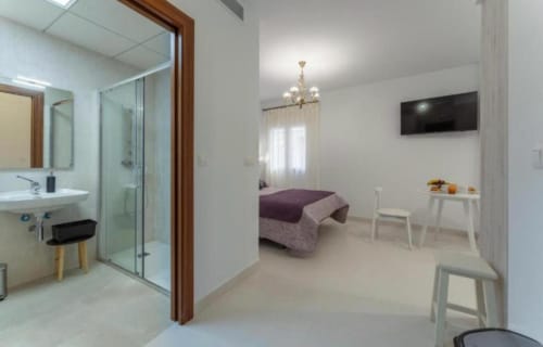 Moderno apartamento estudio en Mérida con baño privado, cama y vistas a la ciudad desde las ventanas