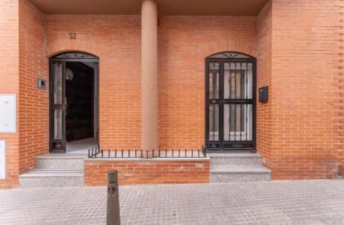 Entrada de edificio de ladrillo con dos puertas arqueadas, vista exterior del edificio de apartamentos en Mérida