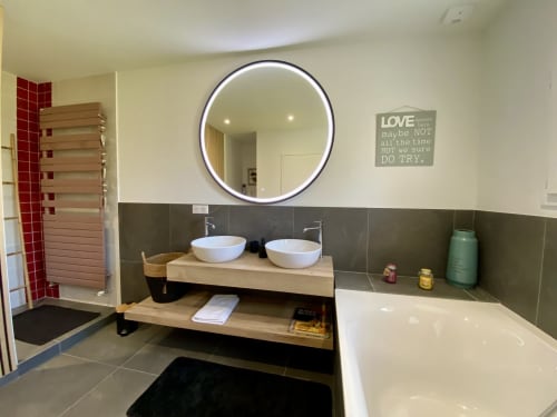 Salle de bain moderne du Lady Jule B&B avec vasque double, miroir LED circulaire et baignoire à Sainte-Luce-sur-Loire