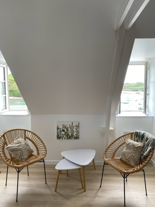 Coin salon moderne avec chaises tressées, table blanche et vue sur la mer à Locmaria Belle Île en Mer