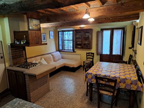 Villa Corte Pincione a Montecarlo con zona living open-plan, sala da pranzo, camino, soffitto con travi e terrazza arredata