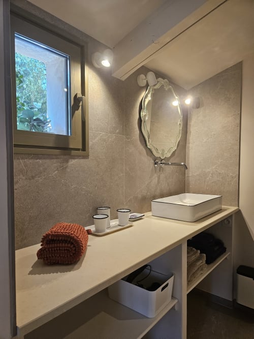 Elegantes Badezimmer mit Design-Waschbecken, antikem Spiegel und warmer Beleuchtung, Comme un Dimanche à Joucas, Luberon, Provence, Frankreich.
